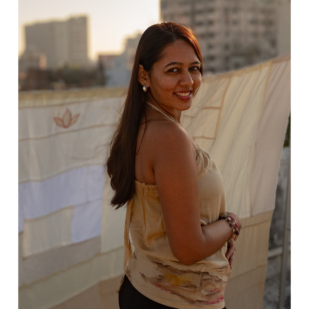 Beige sleeveless cotton summer top with subtle abstract artwork, comfortable top for casual outings and vacations.