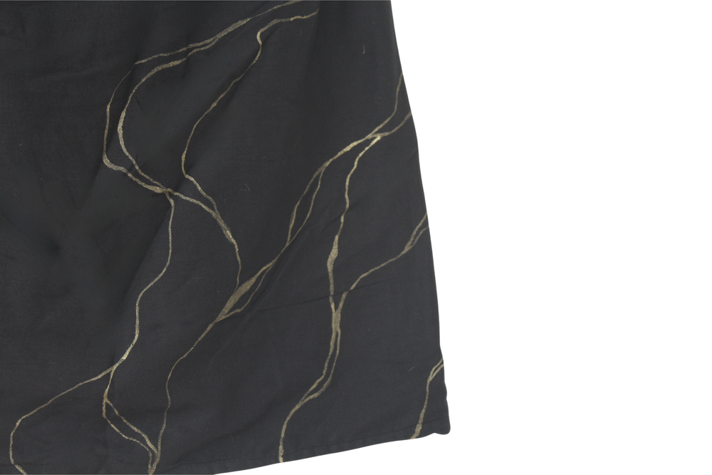 Close-up of a black top with gold thread patterns with golden