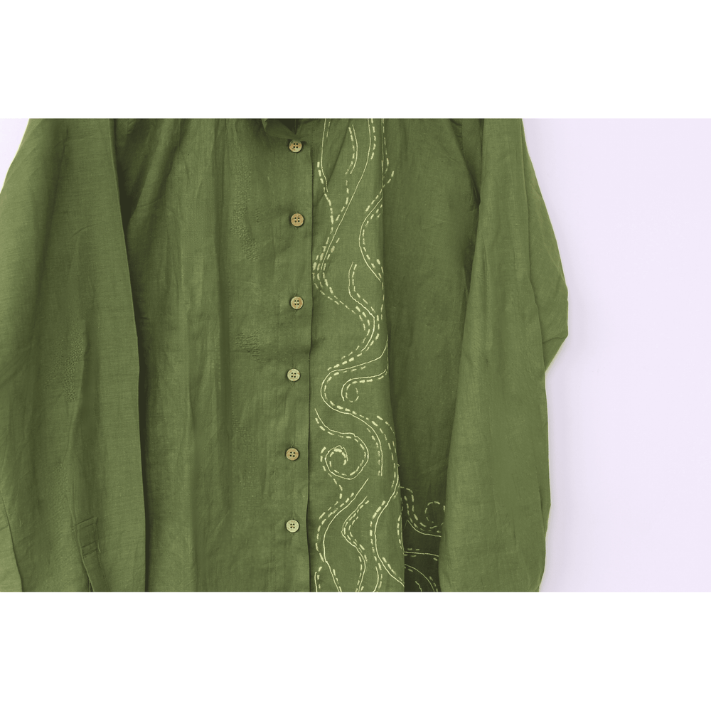 Green shirt with intricate white embroidery on a white background