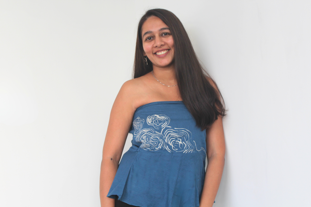 Woman wearing a blue strapless top with white design