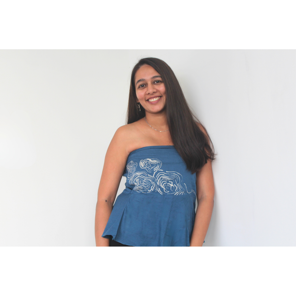 Woman wearing a blue strapless top with white design