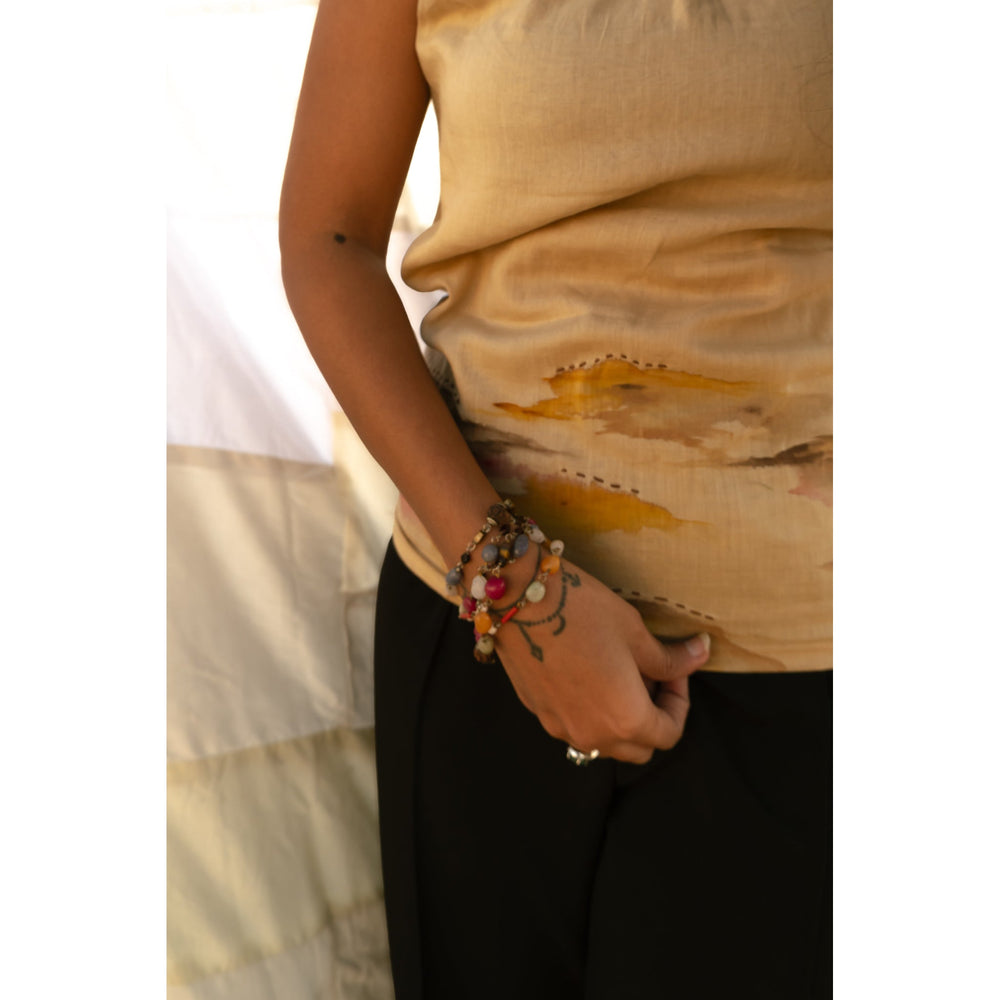 Beige cotton sleeveless top with abstract artwork detail, relaxed summer top for casual outfits and vacation styling.