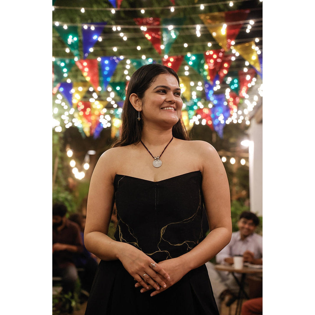 Black corset top featuring artistic gold detailing, strapless party top for evening occasions and festive gatherings.
