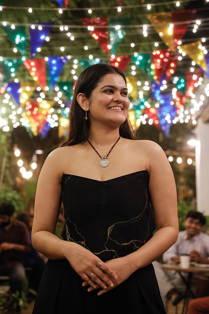 Black corset top featuring artistic gold detailing, strapless party top for evening occasions and festive gatherings.