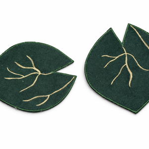 Pair of green leaf-shaped fabric coasters with gold detailing