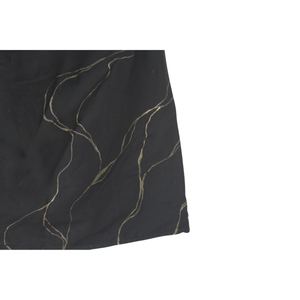 Close-up of a black top with gold thread patterns with golden