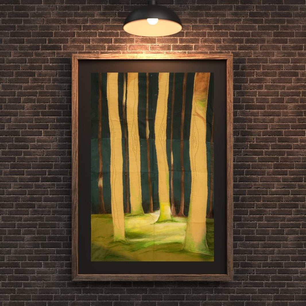 Framed artwork of a forest scene on a brick wall with a light fixture above.