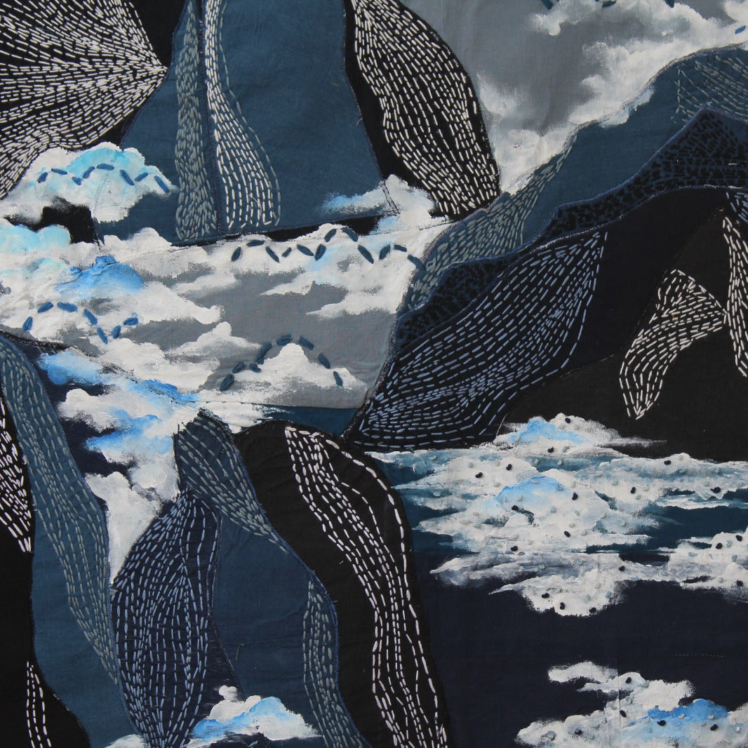 Kantha embroidery depicting mountains and cloud pattern on a dark background