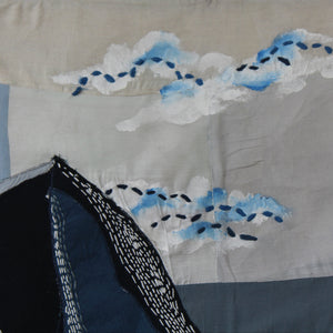 Handmade textile wall art featuring mountain landscape and clouds in deep blue tones, decorative wall art for living rooms, studios and modern interiors.