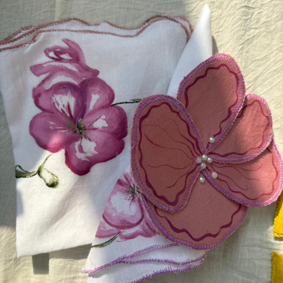 Reusable cotton table napkin with orchid flower illustration and scalloped edges, decorative cloth napkin for dining table and elegant table settings.