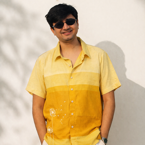 Man wearing a yellow and orange gradient shirt against a light background