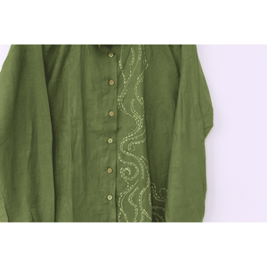Green shirt with intricate white embroidery on a white background
