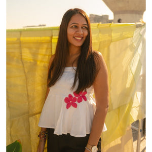 Woman wearing a cotton floral tube top with minimal flower detail, breathable strapless summer top for everyday outfits.