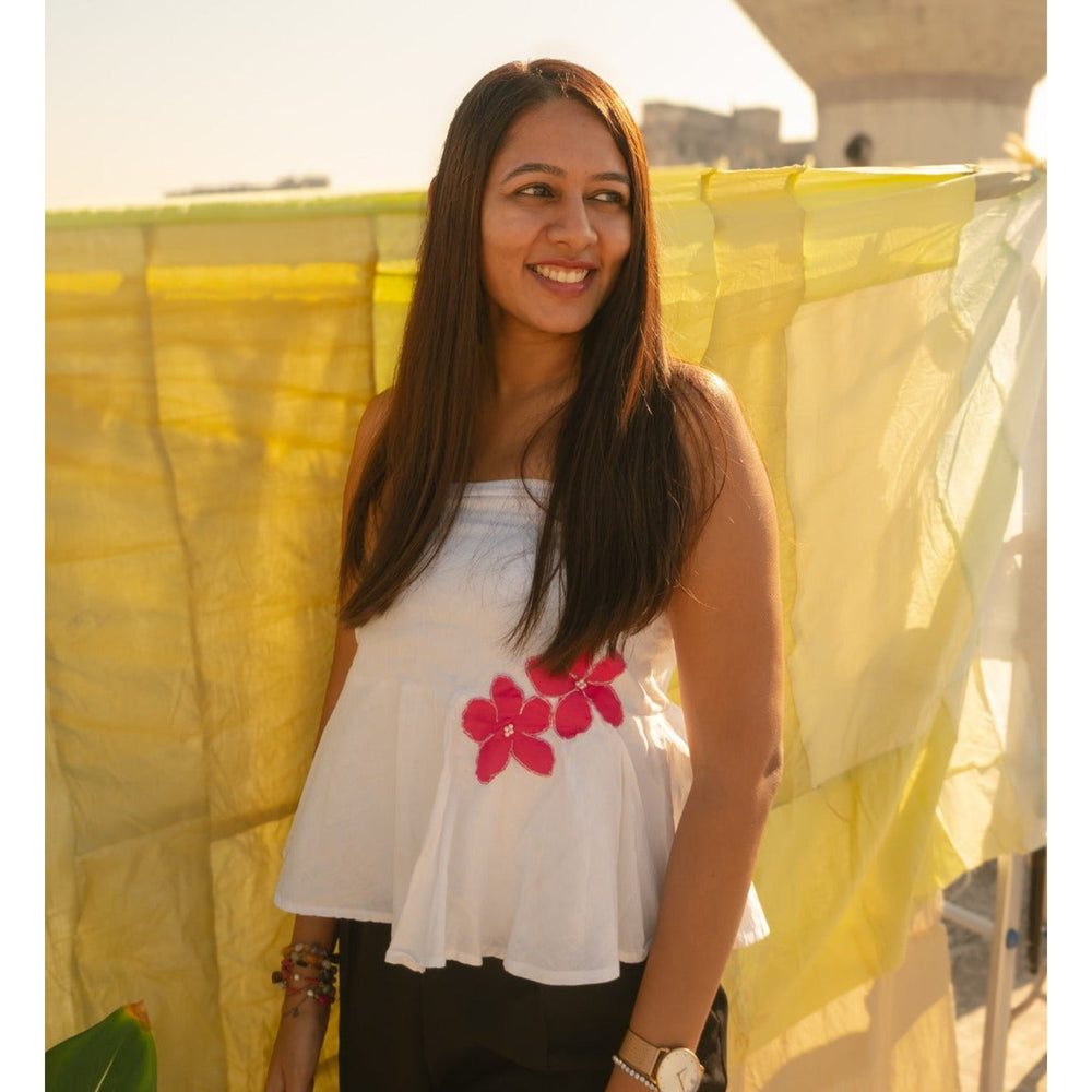 Woman wearing a cotton floral tube top with minimal flower detail, breathable strapless summer top for everyday outfits.