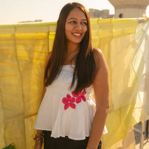 Woman wearing a cotton floral tube top with minimal flower detail, breathable strapless summer top for everyday outfits.