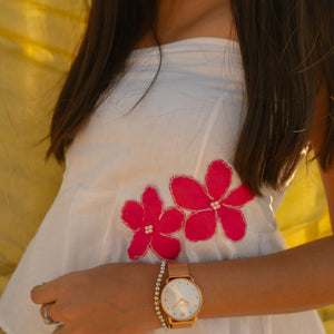 Woman wearing a minimal floral strapless cotton top with handmade flower accents, lightweight summer tube top.