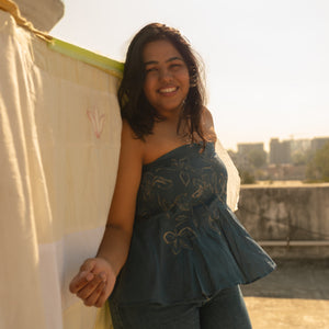 Woman wearing a strapless cotton summer top with artistic line design, lightweight tube top for warm weather outfits.