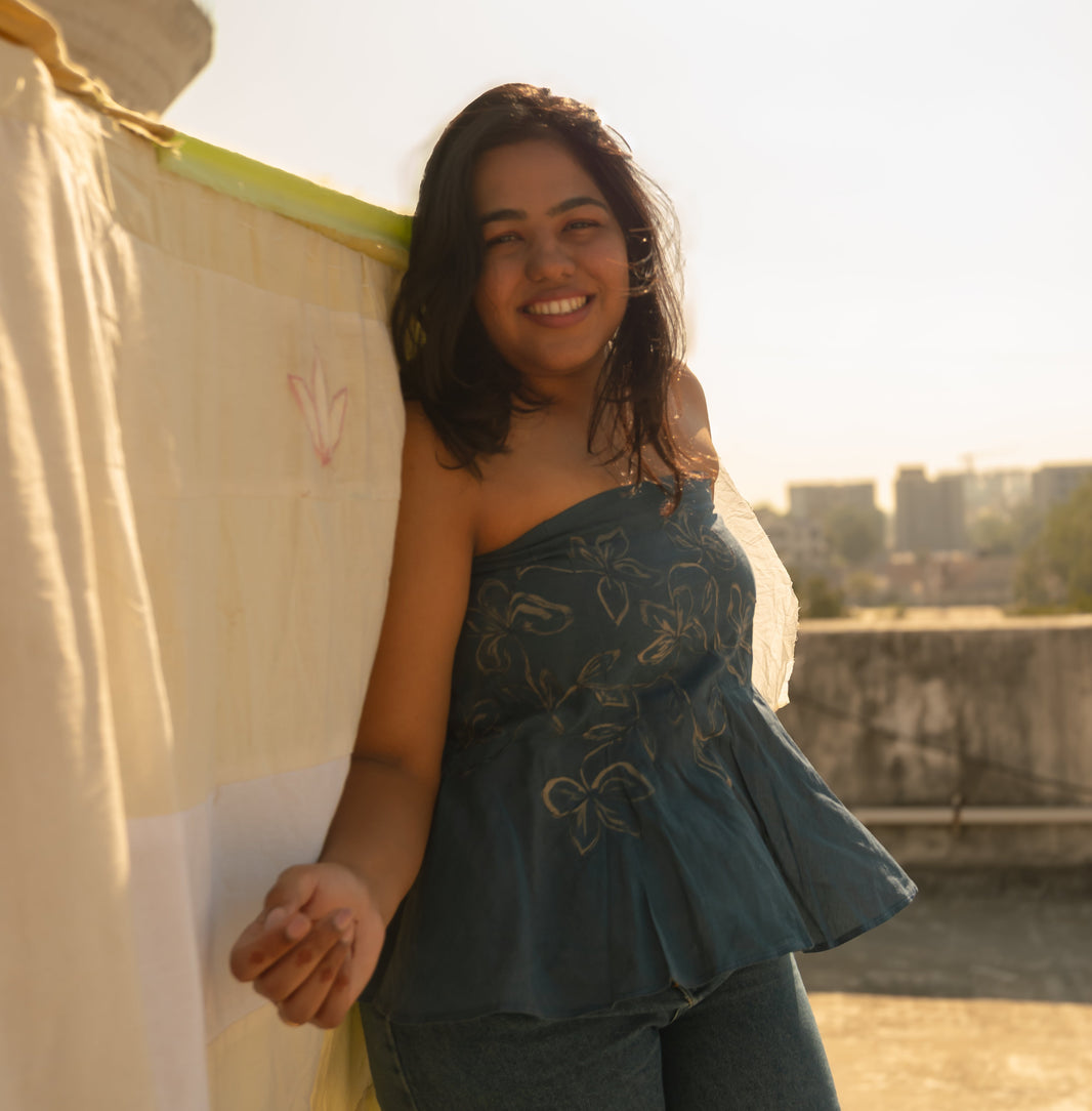 Woman wearing a strapless cotton summer top with artistic line design, lightweight tube top for warm weather outfits.