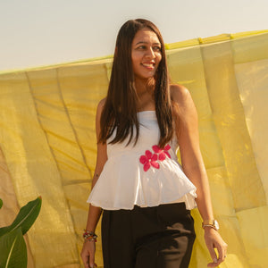 Woman wearing a strapless floral summer top with handcrafted flower accents, lightweight tube top for warm weather styling.