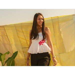 Woman wearing a strapless floral summer top with handcrafted flower accents, lightweight tube top for warm weather styling.