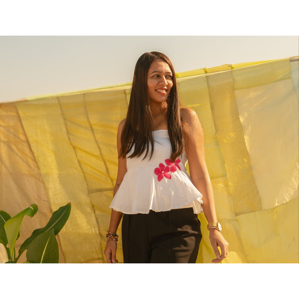 Woman wearing a strapless floral summer top with handcrafted flower accents, lightweight tube top for warm weather styling.